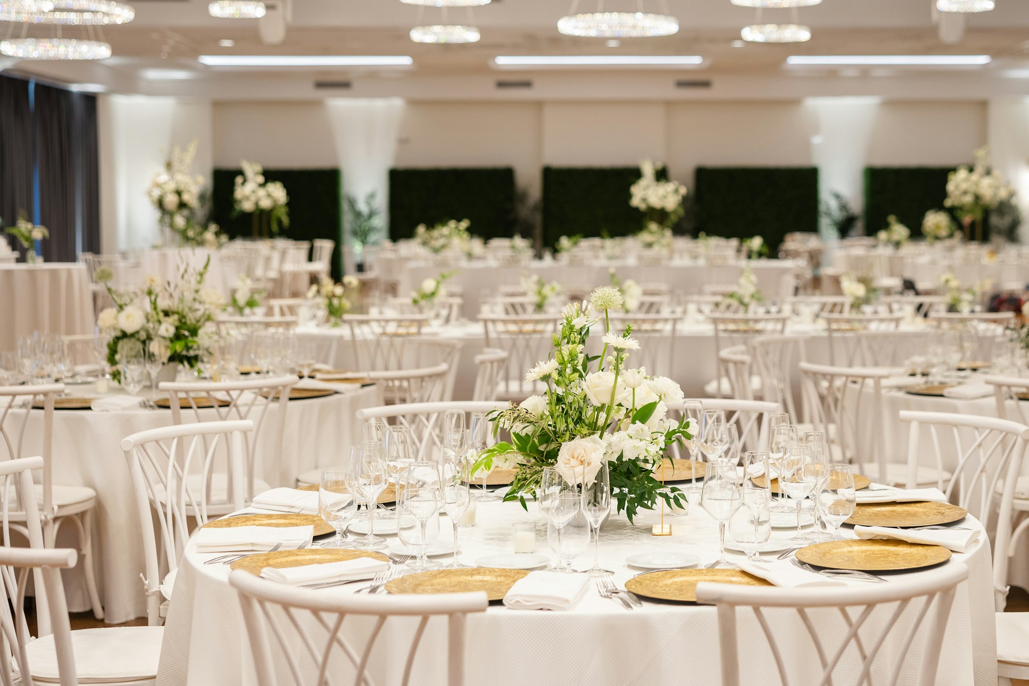 An elegant ballroom reception setup with white linens and floral centerpieces at TillingHouse