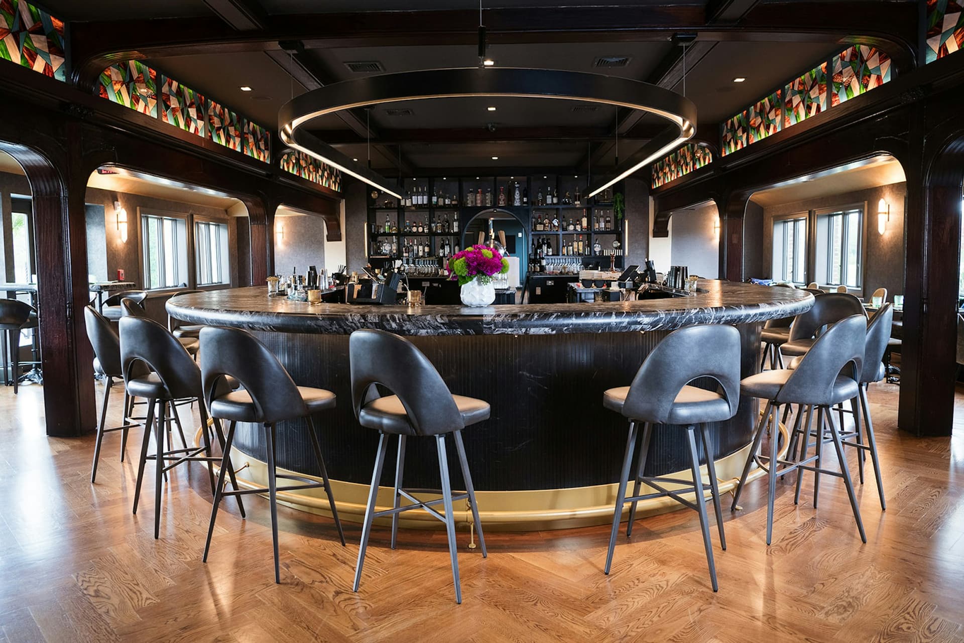 The circular bar with blue leather stools and ring chandelier at TillingHouse
