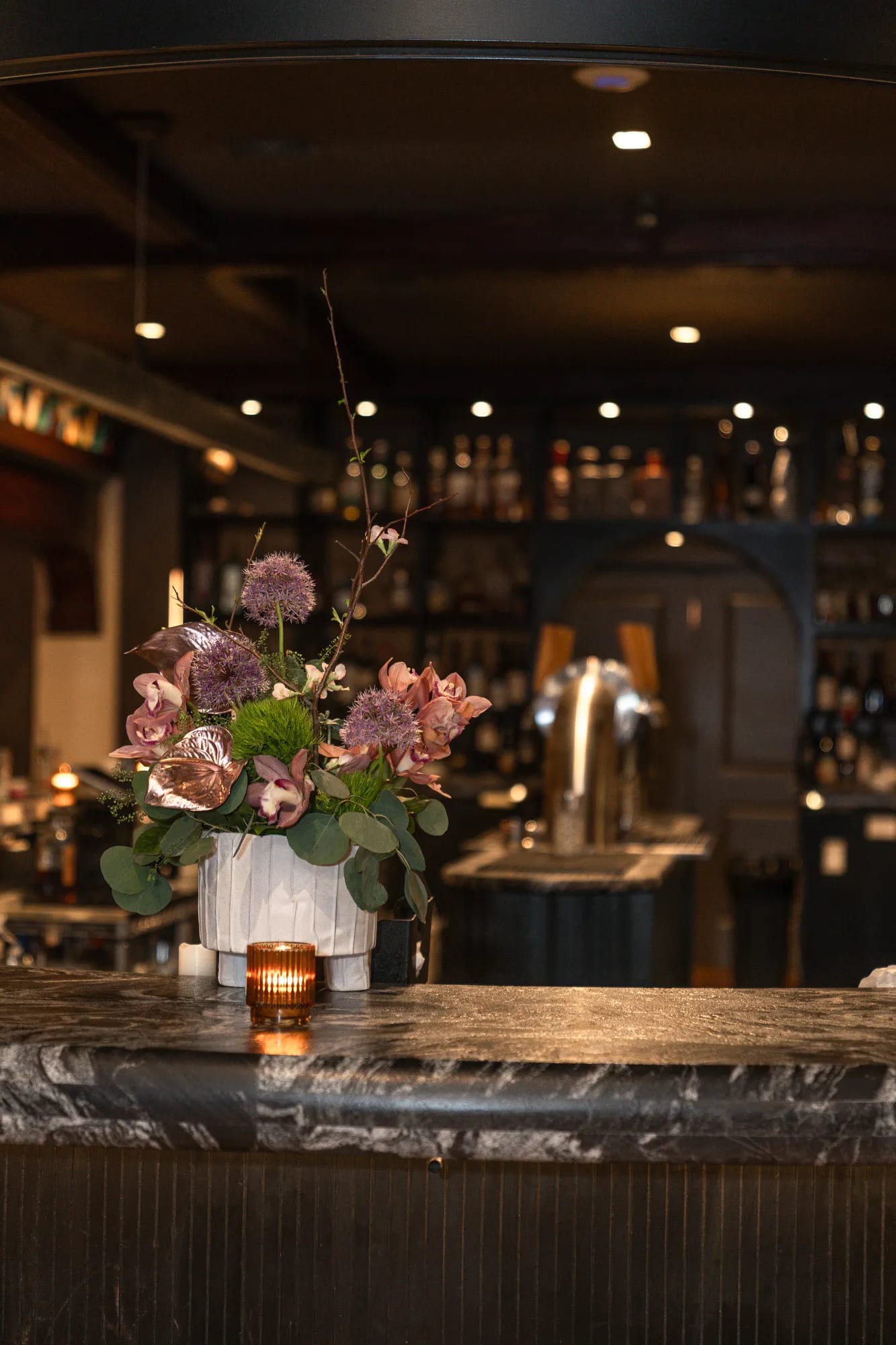 The bar with a floral arrangement and warm lighting at TillingHouse