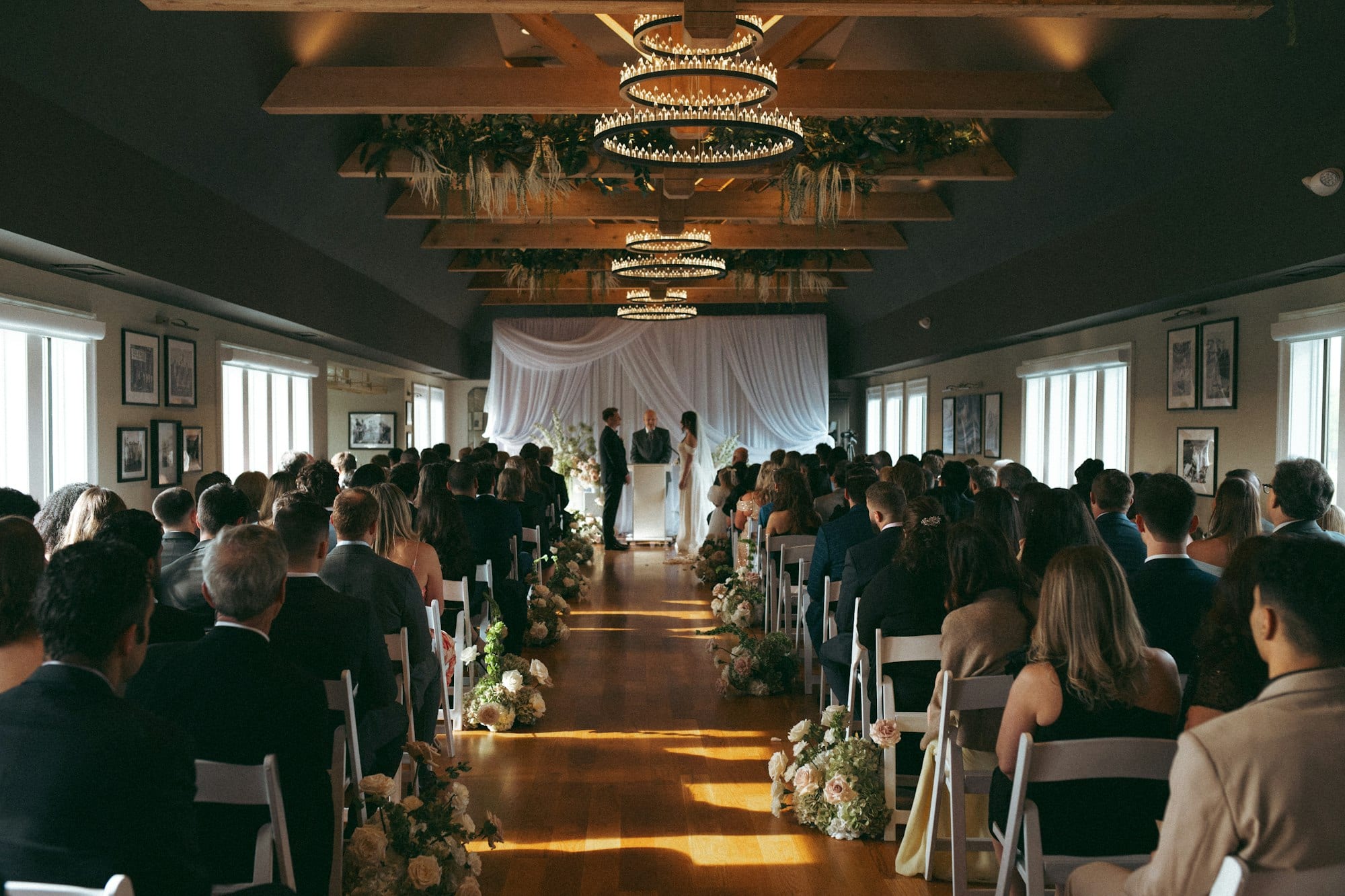 A wedding ceremony aisle inside the chandelier-lit ballroom at TillingHouse