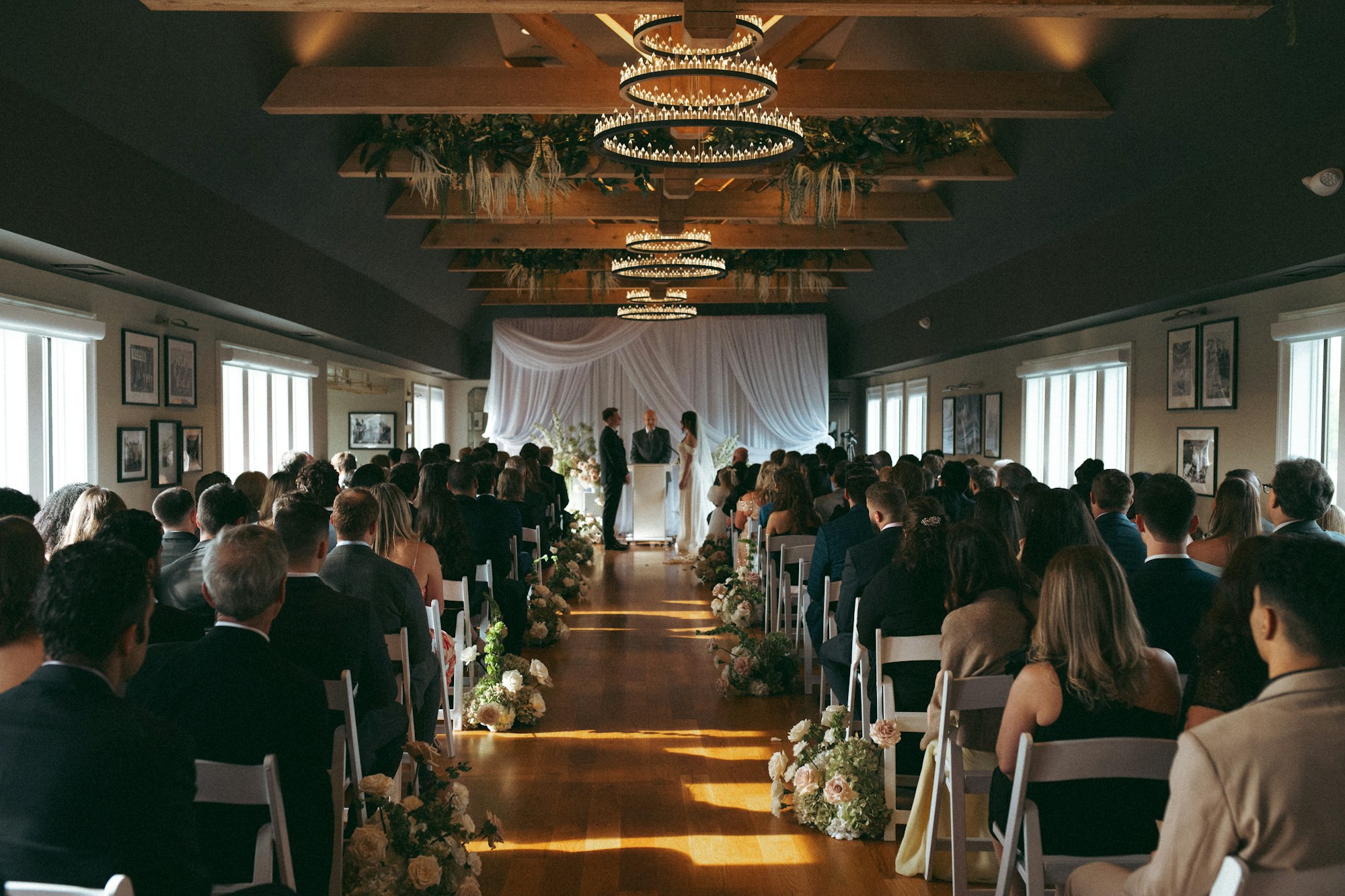 A wedding ceremony aisle inside the chandelier-lit ballroom at TillingHouse