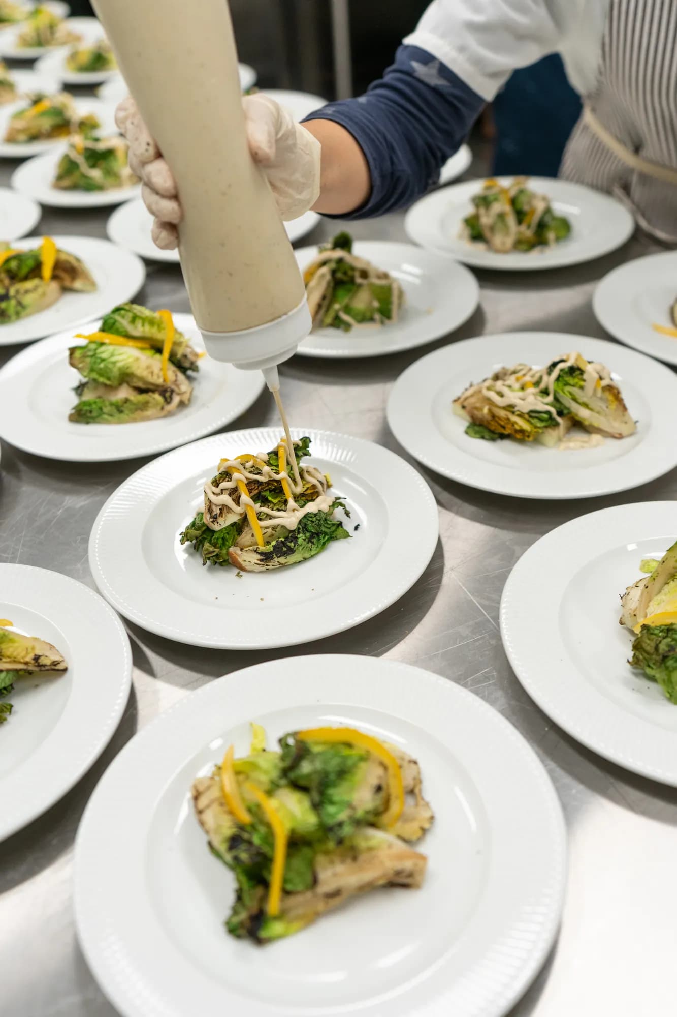 Rows of plated salad courses ready for service at a TillingHouse event