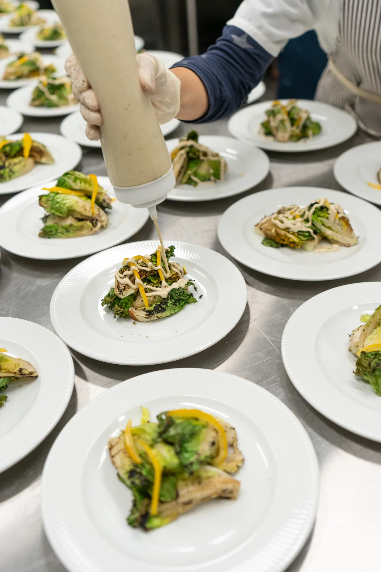 Rows of plated salad courses ready for service at a TillingHouse event