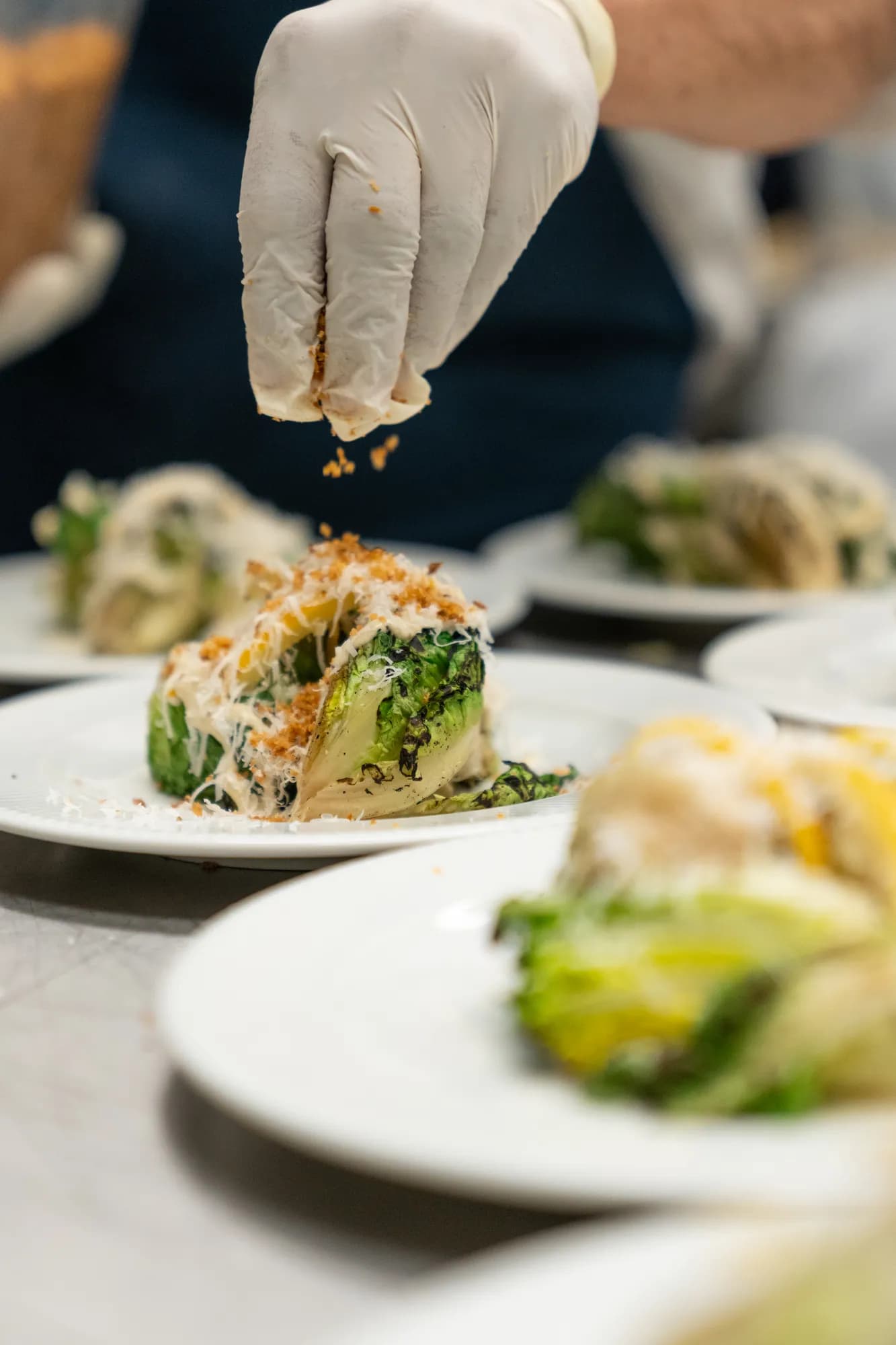 A chef plating a fresh salad course in the TillingHouse kitchen