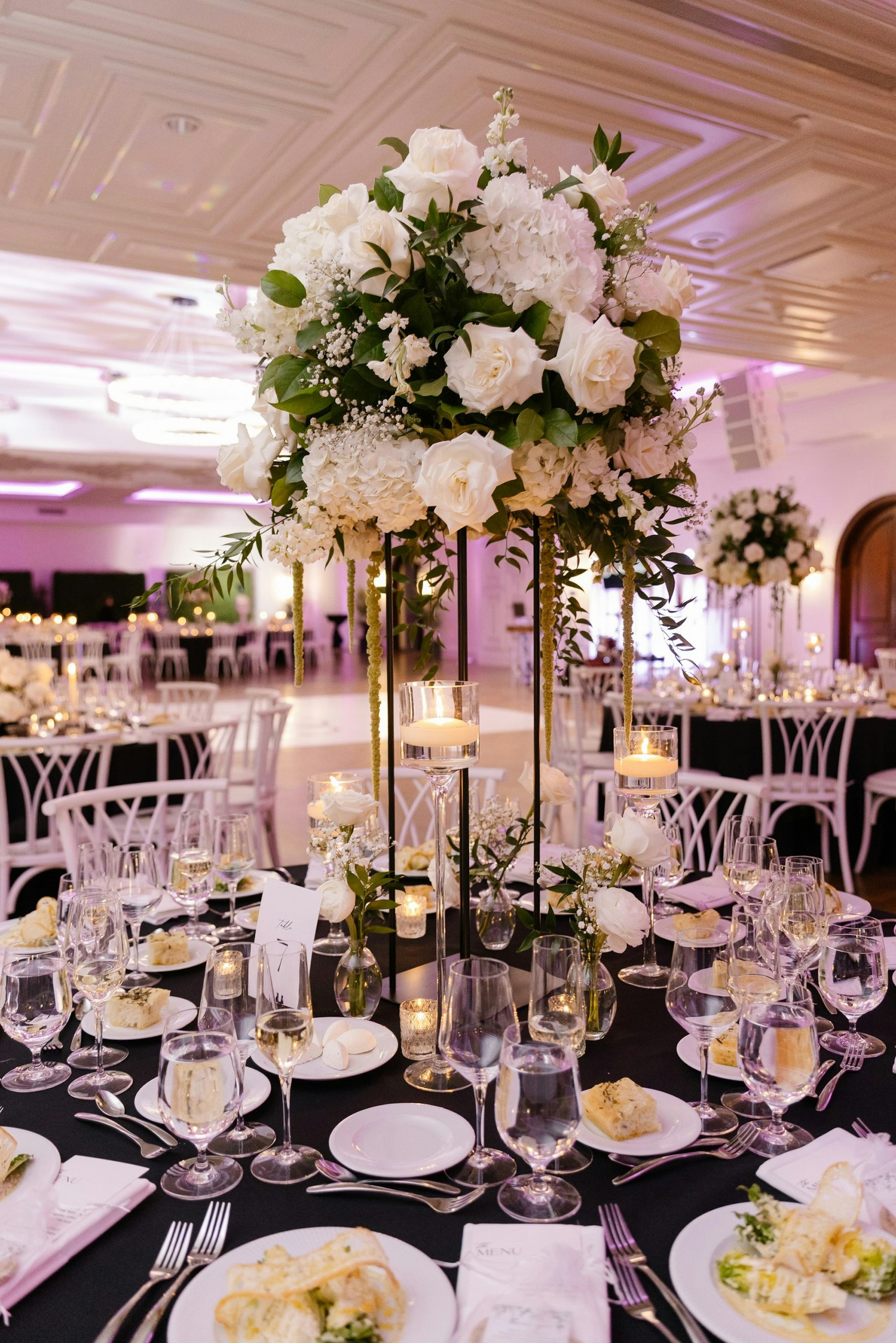 An elegant reception table with a tall floral centerpiece at TillingHouse